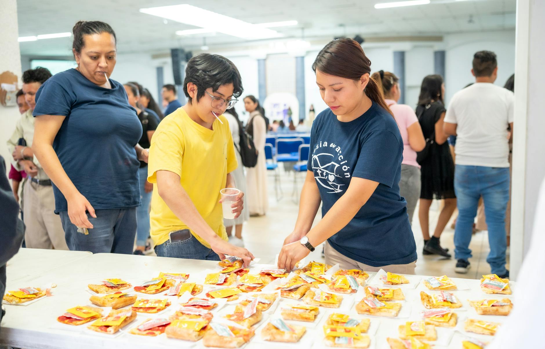 a group of people standing around a table with food